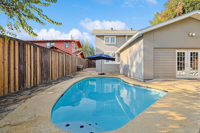 view of swimming pool featuring french doors and a patio area