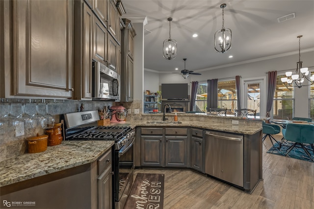 kitchen featuring crown molding, appliances with stainless steel finishes, sink, and plenty of natural light