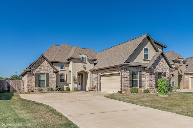 french country home with a front yard and a garage