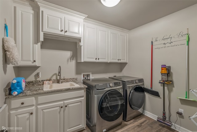 washroom featuring washing machine and dryer, cabinets, sink, and dark hardwood / wood-style floors