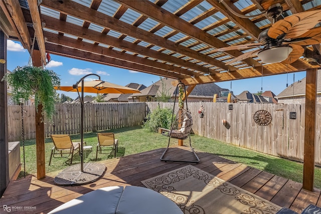 wooden terrace with ceiling fan, a lawn, and a pergola