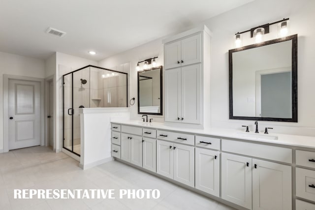 bathroom with walk in shower, vanity, and tile patterned floors