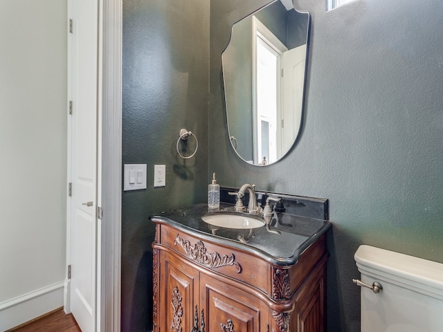 bathroom with vanity, toilet, and wood-type flooring