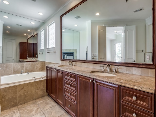 bathroom with vanity, a relaxing tiled tub, a healthy amount of sunlight, and ornamental molding