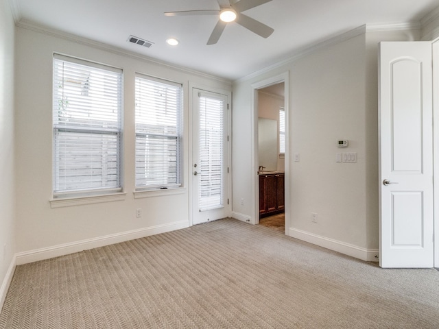 empty room featuring crown molding, light colored carpet, and ceiling fan