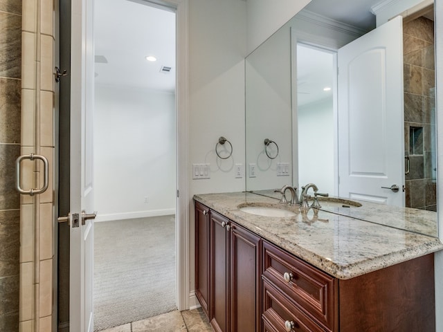 bathroom featuring vanity, ornamental molding, and a shower with shower door