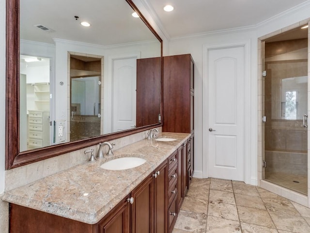 bathroom with vanity, crown molding, and a shower with shower door