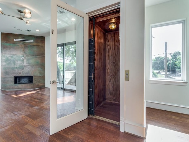 entryway with dark wood-type flooring and a fireplace