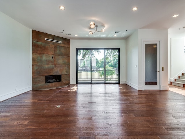 unfurnished living room featuring dark wood-type flooring and a fireplace