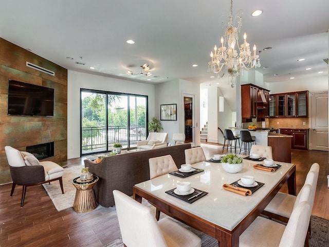 dining room with dark wood-type flooring and a large fireplace