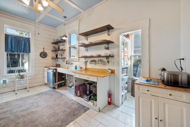 kitchen with wooden walls, appliances with stainless steel finishes, coffered ceiling, and white cabinets