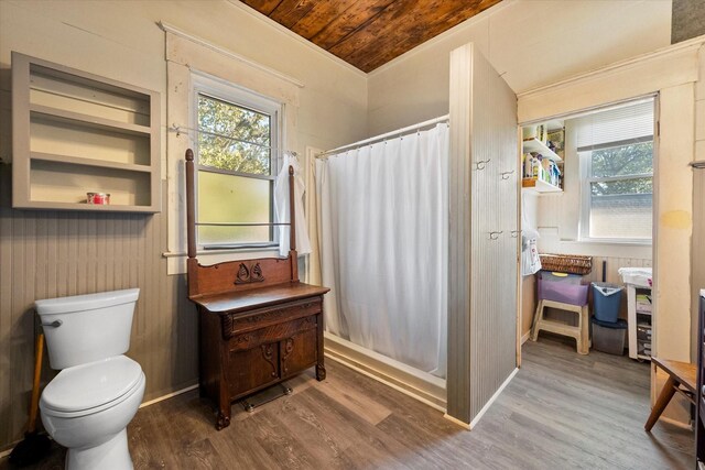 bathroom with wood-type flooring, walk in shower, vanity, and wood walls