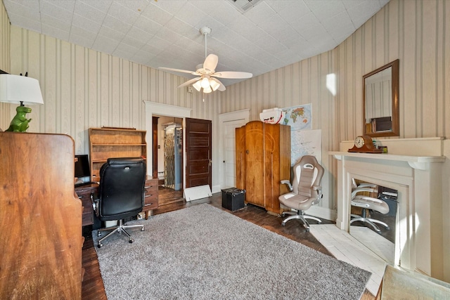 home office with dark wood-type flooring and ceiling fan