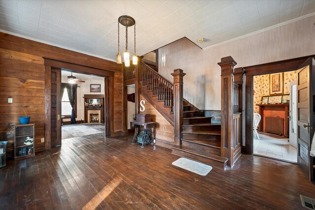 foyer entrance featuring dark hardwood / wood-style flooring and wood walls