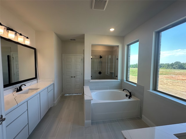 bathroom with vanity, plus walk in shower, and tile patterned flooring