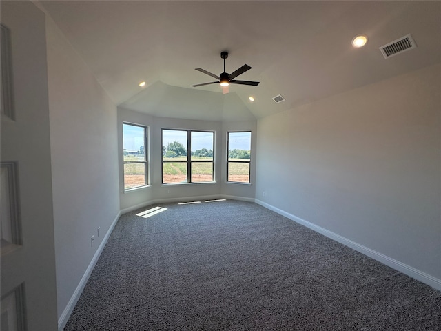 empty room with vaulted ceiling, carpet floors, and ceiling fan