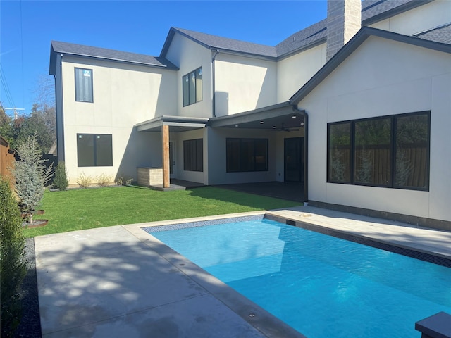 rear view of house with a patio and a lawn