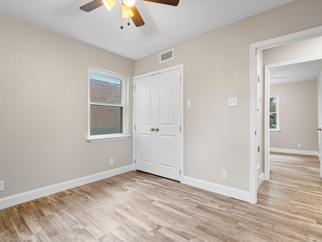 unfurnished bedroom featuring a closet, ceiling fan, and light wood-type flooring