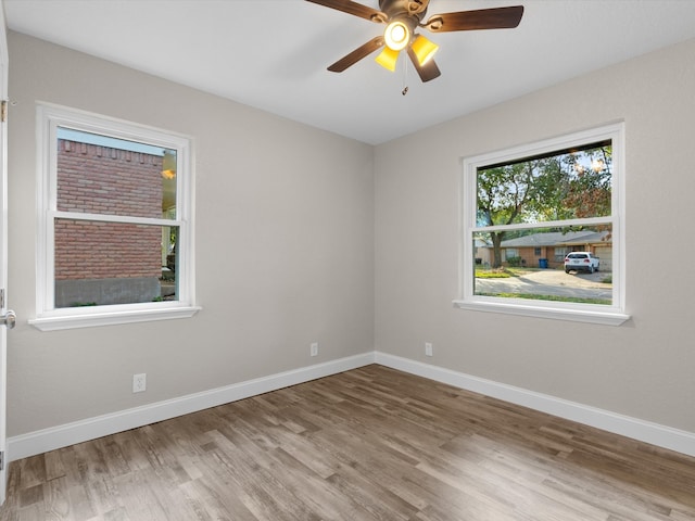 empty room with ceiling fan and light hardwood / wood-style flooring