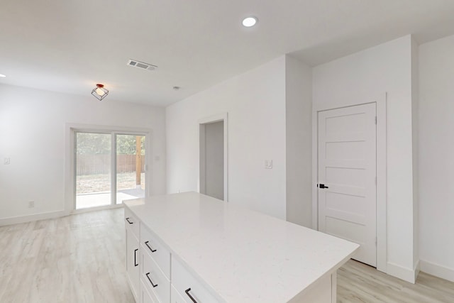 kitchen featuring a center island, white cabinetry, and light hardwood / wood-style floors