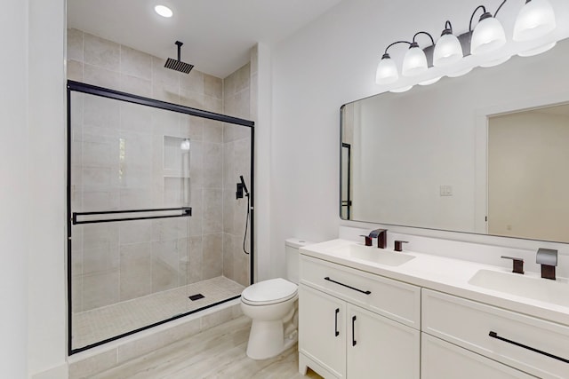 bathroom with toilet, walk in shower, vanity, and hardwood / wood-style flooring