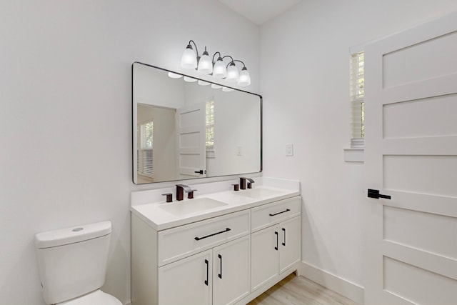 bathroom featuring toilet, hardwood / wood-style floors, and vanity