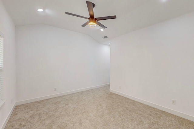 carpeted spare room featuring vaulted ceiling and ceiling fan