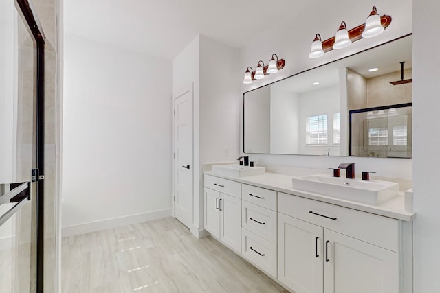 bathroom featuring a shower with door, hardwood / wood-style floors, and vanity