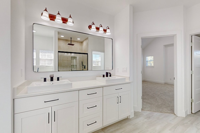 bathroom featuring a wealth of natural light, vanity, hardwood / wood-style floors, and walk in shower