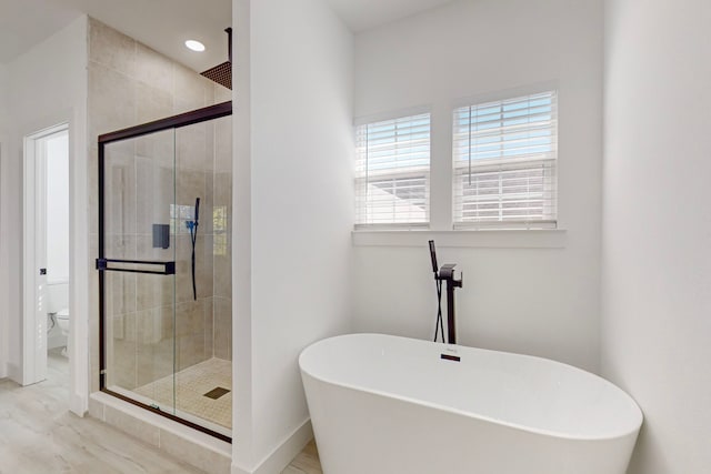 bathroom with toilet and separate shower and tub