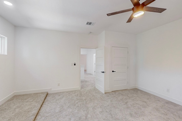 unfurnished room with light colored carpet and ceiling fan