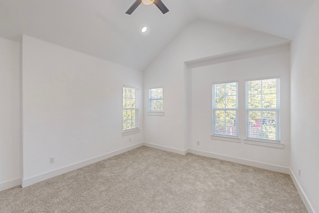 carpeted spare room with vaulted ceiling, a wealth of natural light, and ceiling fan