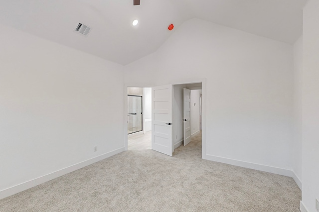 unfurnished bedroom featuring light carpet and high vaulted ceiling