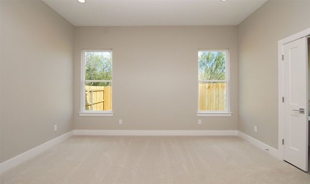 empty room with a wealth of natural light and light carpet