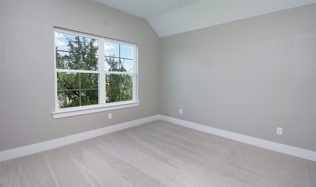 carpeted empty room with lofted ceiling