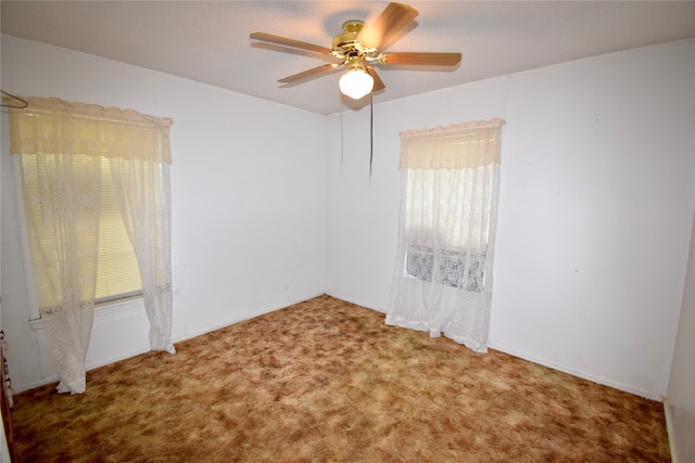 carpeted spare room featuring ceiling fan