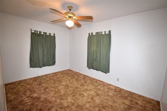 carpeted spare room with a textured ceiling and ceiling fan