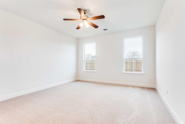 unfurnished room featuring light carpet, ceiling fan, visible vents, and baseboards