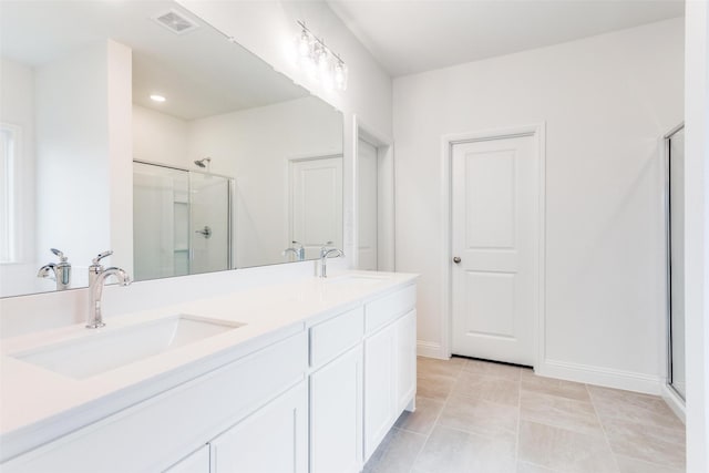 bathroom featuring double vanity, a shower stall, visible vents, and a sink