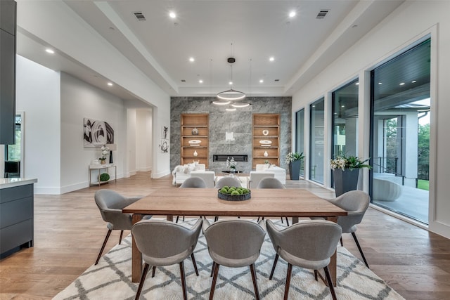 dining space with built in shelves and light wood-type flooring