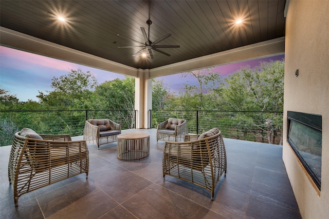 patio terrace at dusk with an outdoor living space and ceiling fan