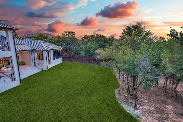 yard at dusk featuring a patio area