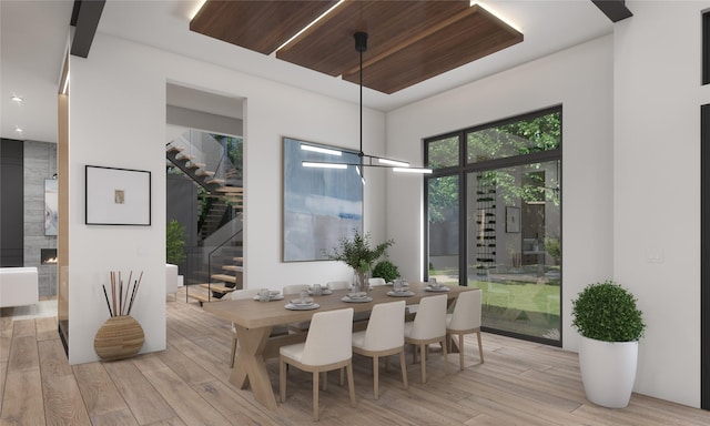 dining area with a notable chandelier, a healthy amount of sunlight, light wood-type flooring, and wood ceiling