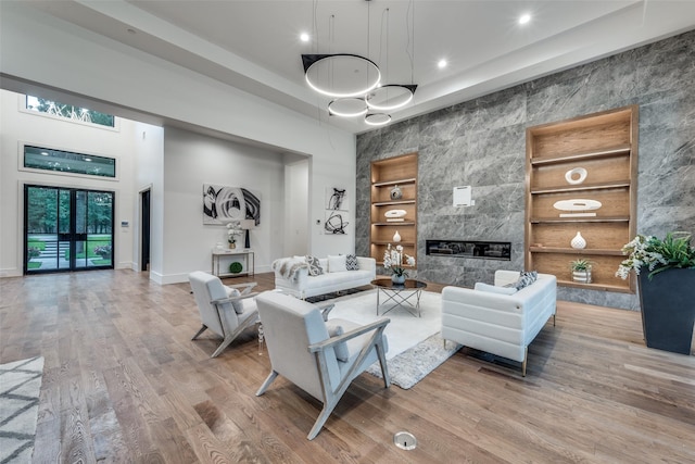 living room featuring a fireplace, built in features, and hardwood / wood-style floors