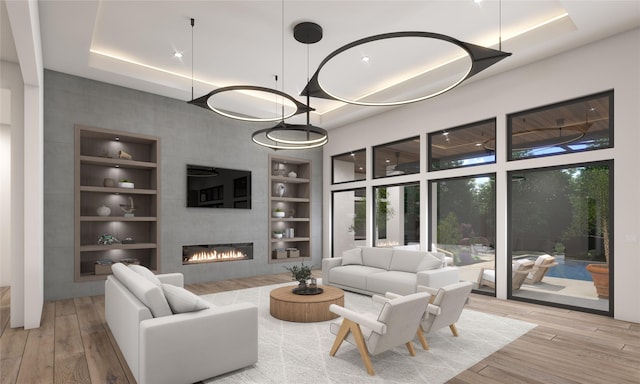 living room featuring built in shelves, a large fireplace, and light wood-type flooring