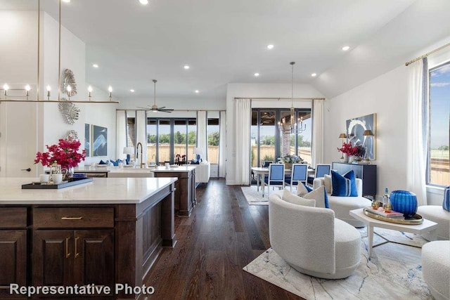 kitchen with dark wood-type flooring, sink, vaulted ceiling, pendant lighting, and ceiling fan