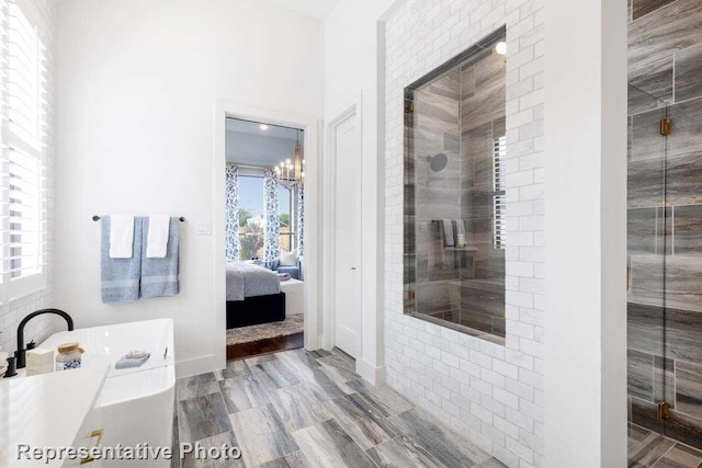 bathroom with a notable chandelier, walk in shower, wood-type flooring, and a wealth of natural light