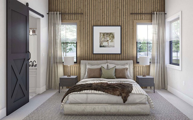 bedroom with light colored carpet, multiple windows, and a barn door