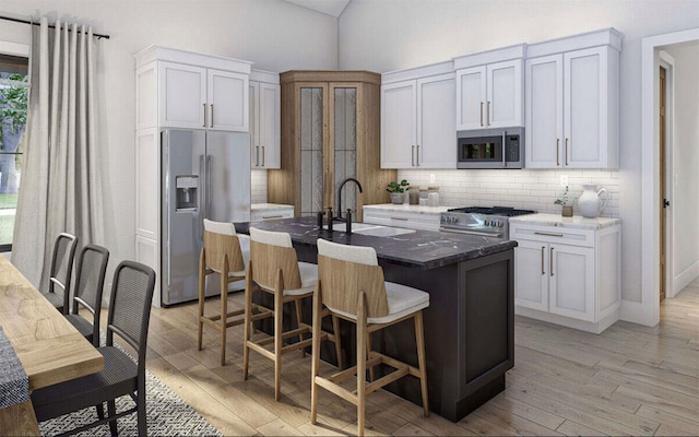 kitchen with a wealth of natural light, appliances with stainless steel finishes, and white cabinets