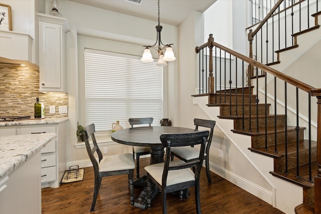 dining space featuring dark hardwood / wood-style floors and a chandelier